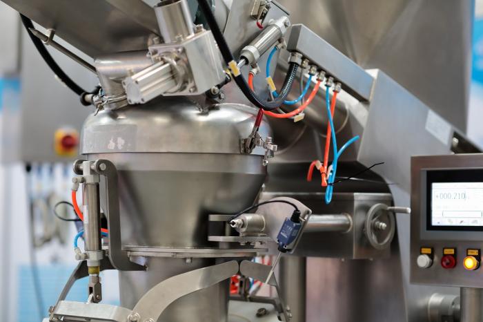 Nowoczesna maszyna pakująca typu flow pack producenta Tarpak pracująca w zakładzie produkcyjnym