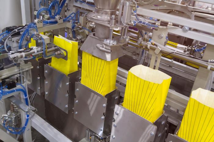 Automatyczna linia do pakowania produktów sypkich z dozownikiem wagowym i systemem transportu.